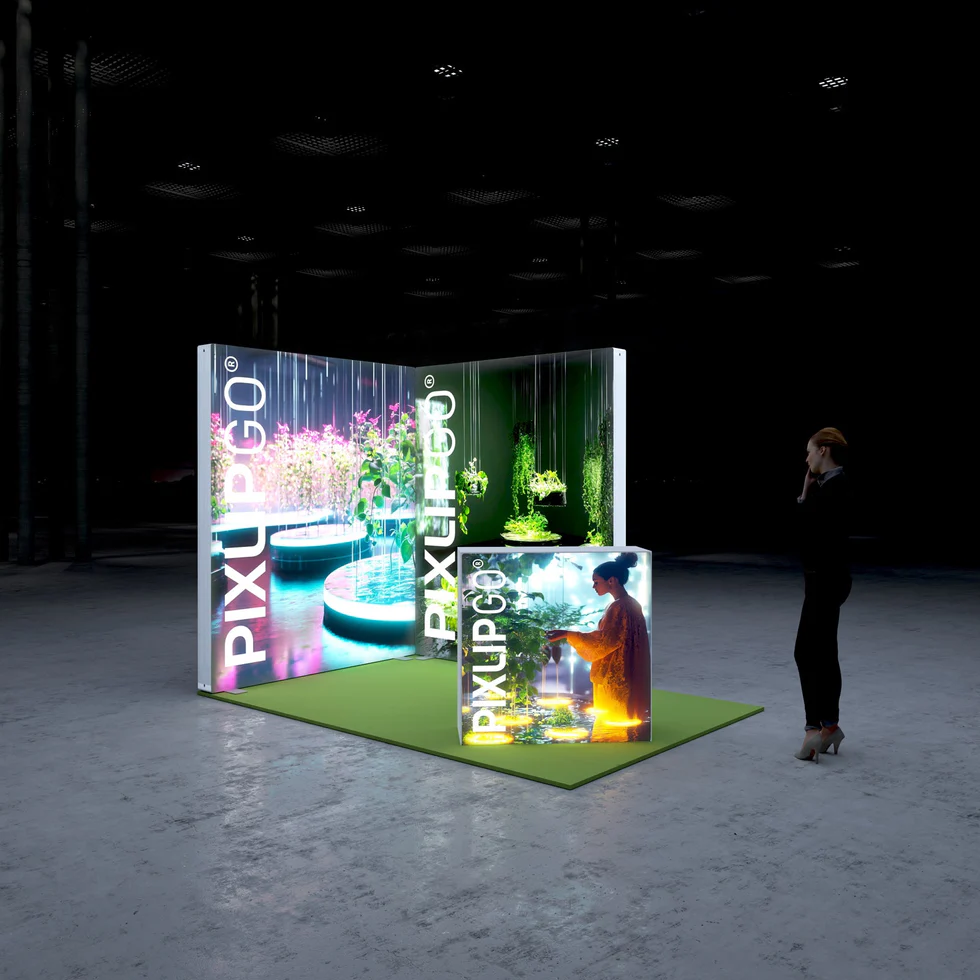 PIXLIP GO Messestand mit großformatigen LED Leuchtwänden und beleuchtetem Counter aus schräger Perspektive für eindrucksvolle Messeauftritte